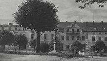 Pohled na Jižní část náměstí v Olešnici v Orlických horách. Tato část se téměř nezměnila, kašna zde stojí dodnes. Fotografie pochází z roku 1935.