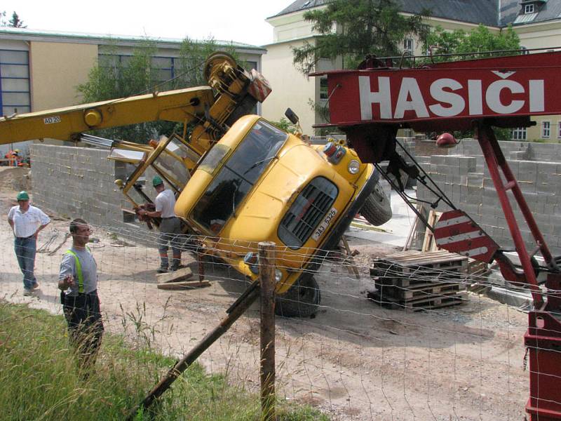 Autojeřáb se převrátil na bok a musel být vyproštěn druhým autojeřábem.