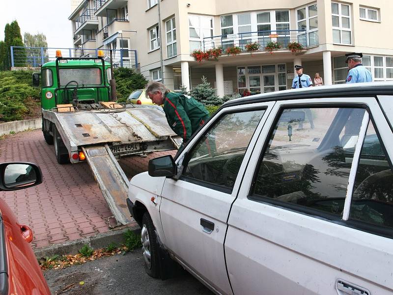 STRÁŽNÍCI městské policie za asistence odtahové služby odstraňují z komunikace automobil, který bránil provozu. 