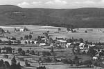 Pohled na obec Říčky v Orlických horách. V pozadí stojí barokní kostel Nejsvětější Trojice obklopen hřbitovem. Snímek je z roku 1955.