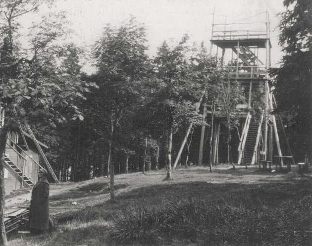 Vyhlídková dřevěná věž na Vrchmezí, 16 metrů vysoká a vedle ní, ale už na německé straně, stávala chata s hostincem. V roce 1946 chata vyhořela. Fotografie pochází z roku 1926.