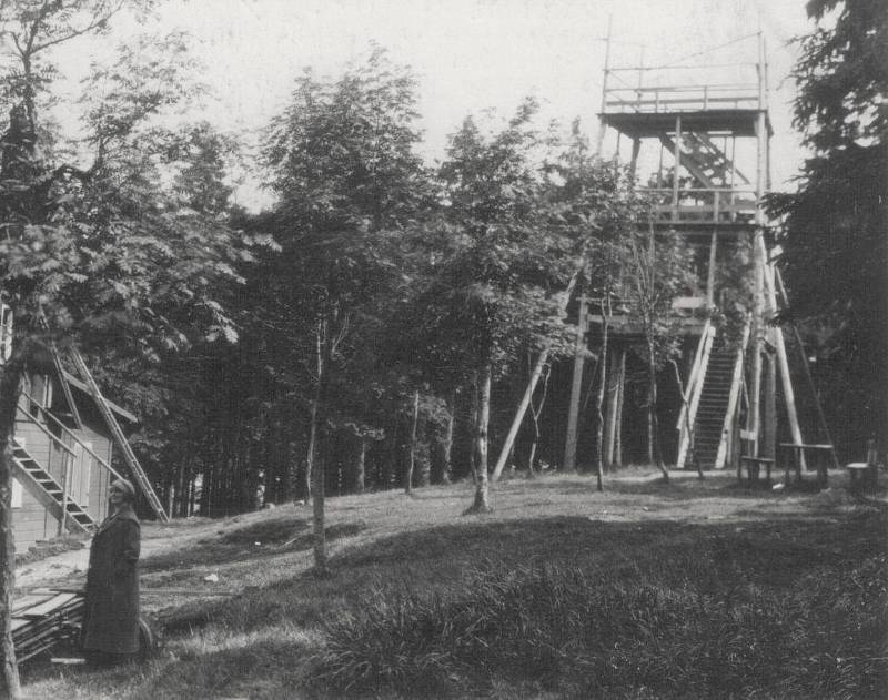 Vyhlídková dřevěná věž na Vrchmezí, 16 metrů vysoká a vedle ní, ale už na německé straně, stávala chata s hostincem. V roce 1946 chata vyhořela. Fotografie pochází z roku 1926.