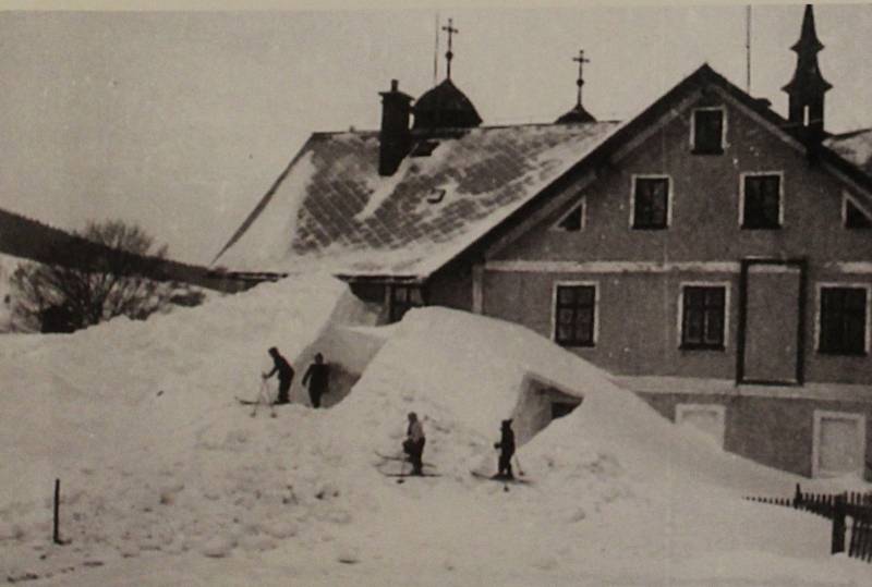 Nafoukaný sníh za koloniálem Michel s mladými lyžaři. Z publikace Deštné v Orlických horách na starých pohlednicích (Muzeum zimních sportů, turistiky a řemesel)