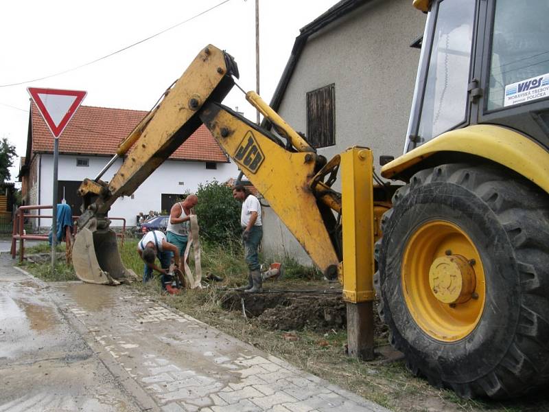 Prasklé potrubí na Družstevní ulici v Poličce bylo ukryté ve dvoumetrové hloubce. Vodohospodáři museli nejprve vyčerpat vodu z jámy, aby mohli opravit přerušené ocelové trubky.