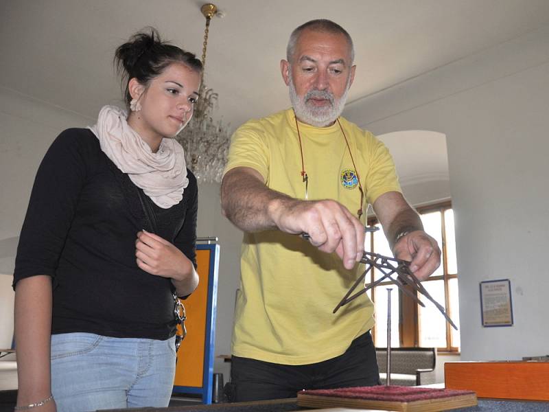 Bohuš Blecha ukazuje, jak na sebe naskládat několik hřebíků, aby nespadly. 