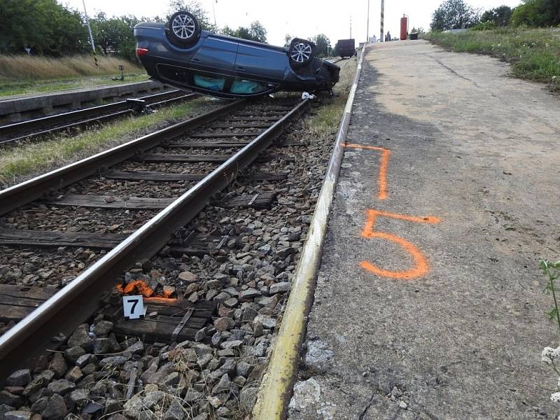 Ujíždějící řidič nakonec auto otočil na střechu poté, co vletěl do kolejiště.