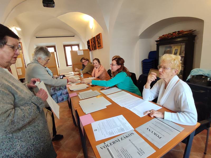 V jednom okrsku v Litomyšli volí lidé v městské knihovně mezi regály s knihami.