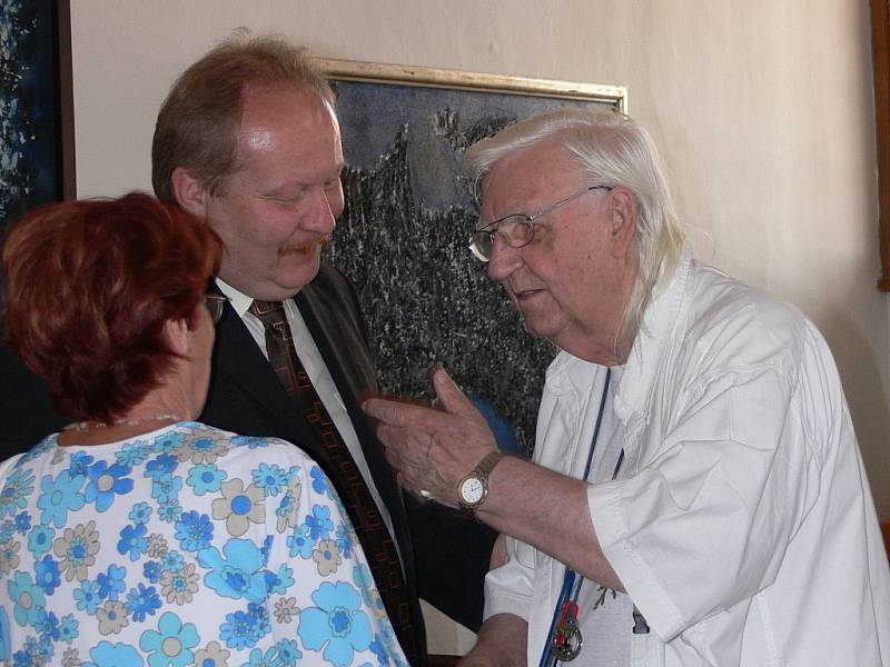 Malíř Bohdan Kopecký (v bílém) při vernisáži své výstavy.