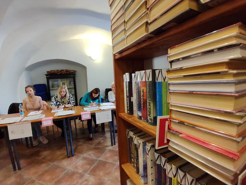 V jednom okrsku v Litomyšli volí lidé v městské knihovně mezi regály s knihami.