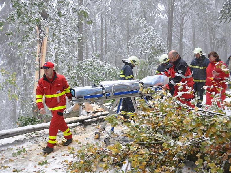 Předání pacienta na Hřebči. Sanity nemohly projet z důvodu popadaných stromů.