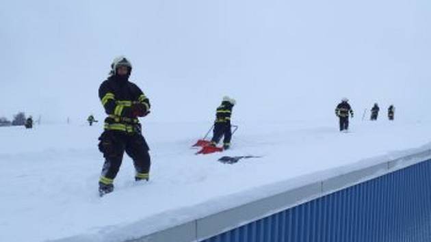 Odklízení sněhu ze střechy zimního stadionu v Poličce