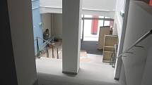 Stěhování knihovny do Fabriky. Mobiliář se nevejde do výtahu, proto musí být vynášen do skladů v horním patře budovy po schodech.