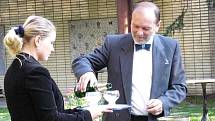 Náměstek ministra kultury Mikeš rozlévá šampanské na křest. 