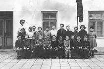 Základní škola v obci Loukov u Mnichova Hradiště. Píše se patrně rok 1962. Nahoře stojí paní učitelka Pejšková.