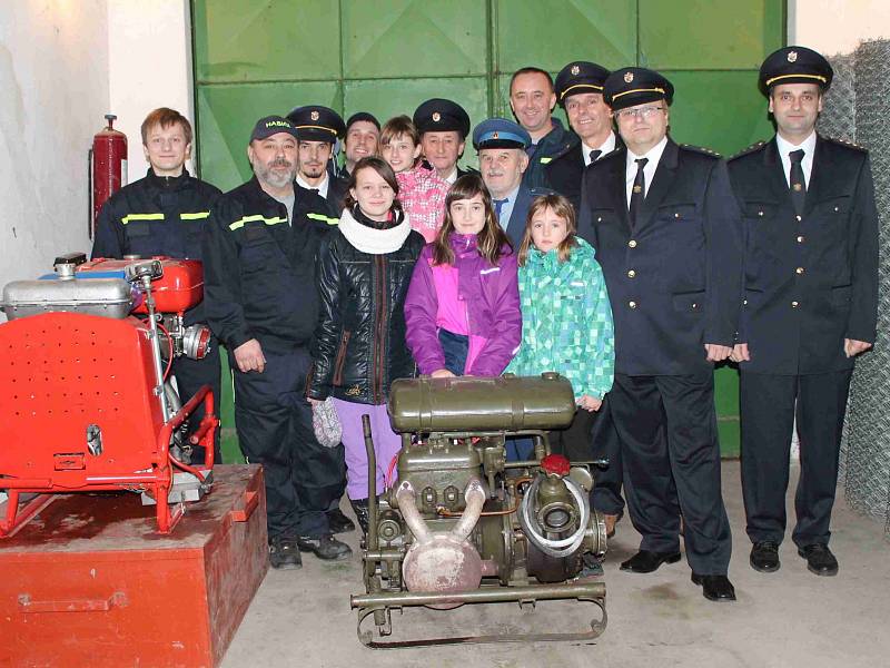 DOBROVOLNÍ hasiči ze Suhrovic pózují v hasičské zbrojnici u techniky.