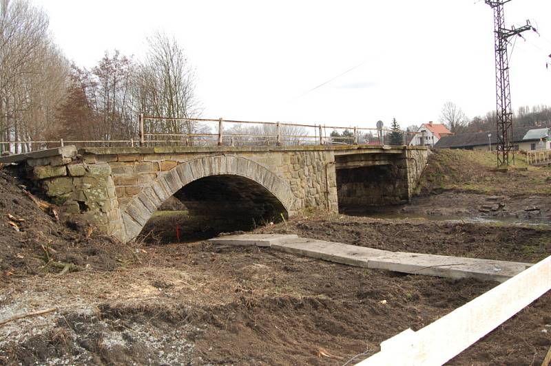 Místo jízdy přes most čeká na řidiče zátaras a několik pařezů na silnici. To vše kvůli rekonstrukci mostu.