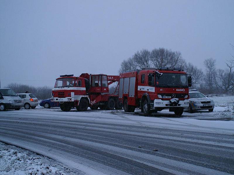 Hasičské vozy, které přijely od místa neštěstí, čekají na křižovatce u hlavní silnice