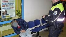 Poliklinika Modrá Hvězda. Na lavičce spí opilý bezdomovec. Strážníci městské policie jej po probuzení a vyřešení záležitosti vyvedli ven.