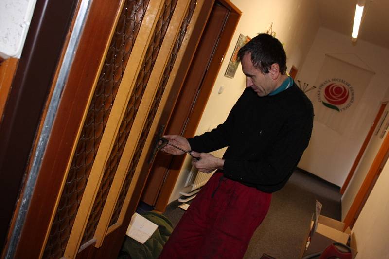 Zámečník opravuje vylomené dveře kanceláří ČSSD v Mladé Boleslavi.