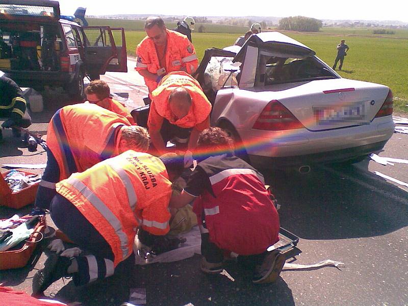 Záchranáři se snaží pomoci řidiči mercedesu, kterého z vraku vyprostili mladoboleslavští hasiči. 