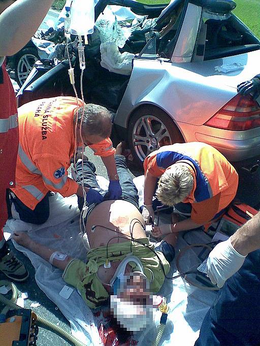 Záchranáři se snaží pomoci řidiči mercedesu, kterého z vraku vyprostili mladoboleslavští hasiči. 