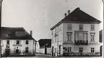 U Bílého beránka (vlevo), Víta Nejedlého 9. Foto je z roku 1890. V roce 1924 byl nahrazen jednopatrovou novostavbou na upravené uliční čáře.