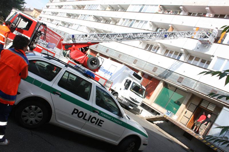 Hasiči, záchranáři a policisté při zásahu u páru, který v pátek dopoledne vyhrožoval skokem z okna na náměstí Míru v Mladé Boleslavi.