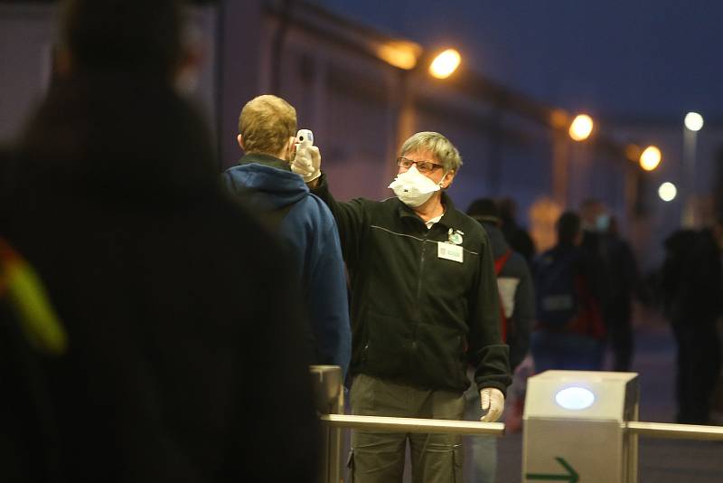 Zaměstnanci Škody Mladá Boleslav přicházejí v pondělí 27. dubna před šestou ráno do práce, po odstávce způsobené epidemií nového typu koronaviru.