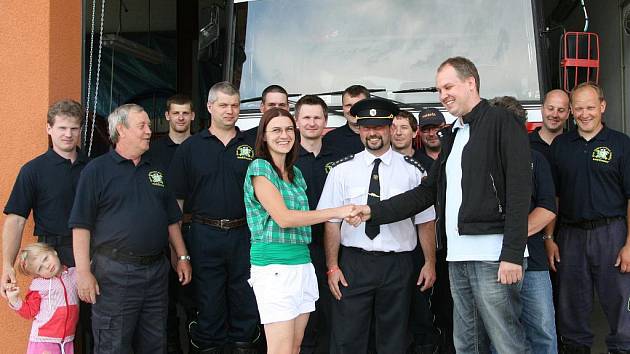 Hasiči z Kněžmosta před hasičskou zbrojnicí s Jitkou Bartošovou a Robinem Povšíkem.