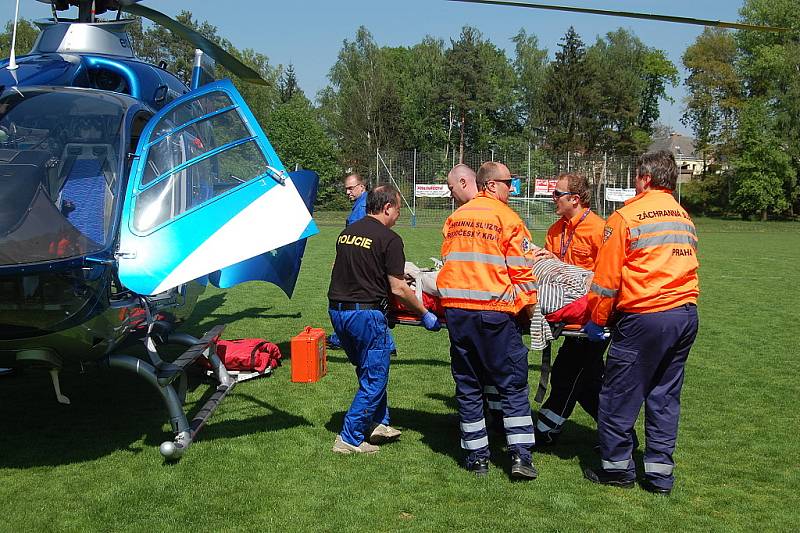 Záchranka zraněného muže převezla ze stavby, kde se zřítil, na bakovské fotbalové hřiště, kde přistál vrtulník a transportoval jej do nemocnice na pražských Vinohradech.