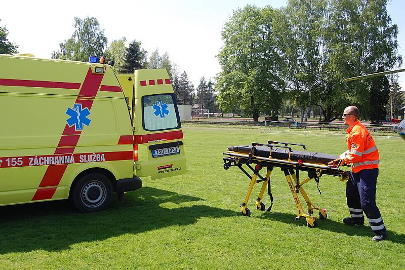 Záchranka zraněného muže převezla ze stavby, kde se zřítil, na bakovské fotbalové hřiště, kde přistál vrtulník a transportoval jej do nemocnice na pražských Vinohradech.