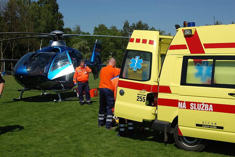 Záchranka zraněného muže převezla ze stavby, kde se zřítil, na bakovské fotbalové hřiště, kde přistál vrtulník a transportoval jej do nemocnice na pražských Vinohradech.