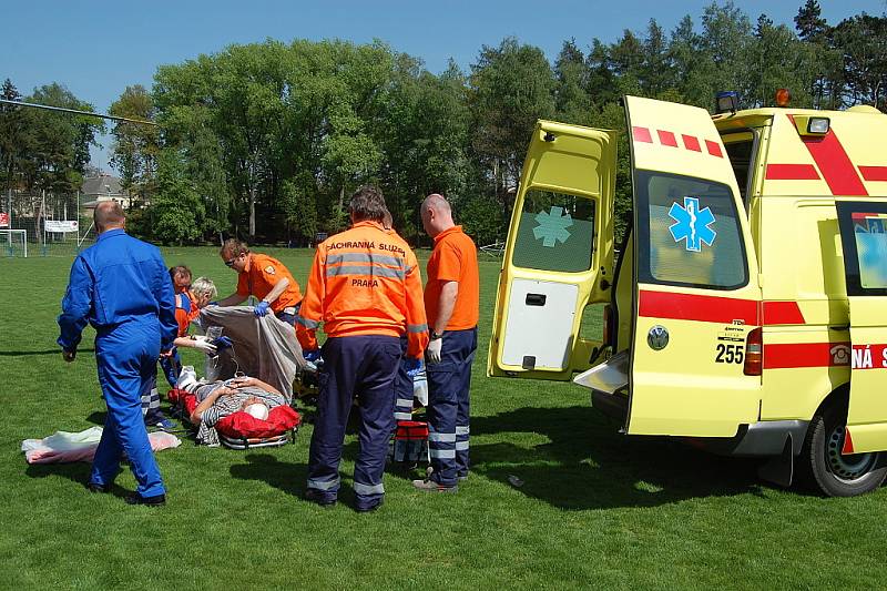 Záchranka zraněného muže převezla ze stavby, kde se zřítil, na bakovské fotbalové hřiště, kde přistál vrtulník a transportoval jej do nemocnice na pražských Vinohradech.