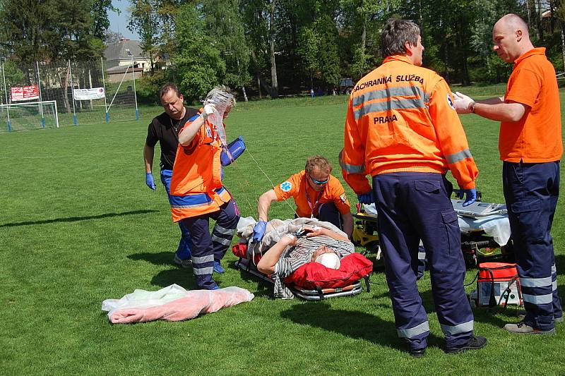 Záchranka zraněného muže převezla ze stavby, kde se zřítil, na bakovské fotbalové hřiště, kde přistál vrtulník a transportoval jej do nemocnice na pražských Vinohradech.