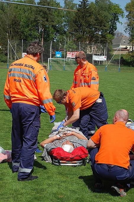 Záchranka zraněného muže převezla ze stavby, kde se zřítil, na bakovské fotbalové hřiště, kde přistál vrtulník a transportoval jej do nemocnice na pražských Vinohradech.