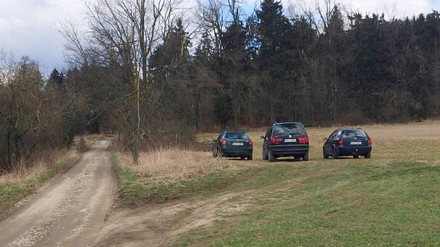 Auta parkující u lesa po rozhlednou na Pekelném kopci. 