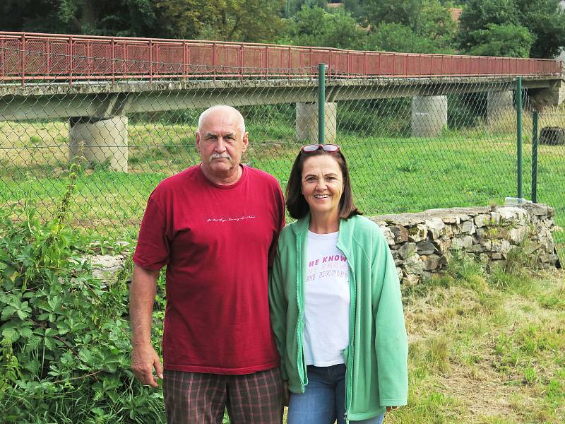 Zdeněk a Marie Vrtalovi na své zahradě. Hned za ní teče řeka, zahrada bývá tedy občas pod vodou. Za nimi je lávka pro pěší, kterou velká voda strhla v 90. letech minulého století.