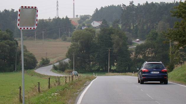 Zatáčky mezi Třebíčí a Pocoucovem se mají dočkat narovnání. Budoucí novou silnici už nyní lemuje na dřevěných kůlech zavěšený kabel optické sítě.