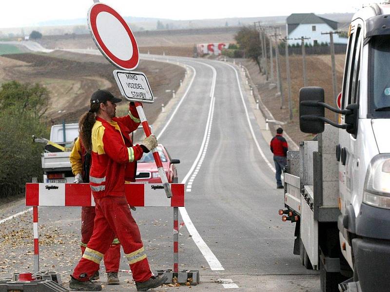 Dělníci stavební firmy odstraňují zátaras, který od června bránil řidičům v průjezdu staveniště. Mnozí očekávali zprůjezdnění hlavní trasy z Třebíče na Moravské Budějovice s velkou nedočkavostí.