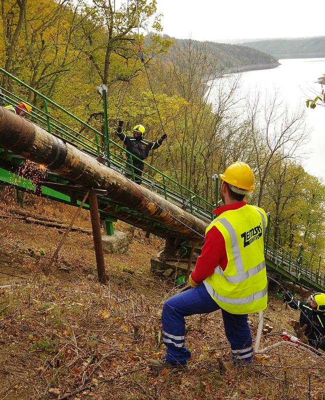 Vrtulník odnášel trubky na nedaleké pole, odkud nabíral nové. Šlo o dokonalou souhru bez zbytečných prostojů.