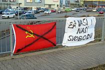 Přeškrtnutá sovětská vlajka a transparent u obchodního centra Stop-Shop.