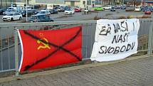 Přeškrtnutá sovětská vlajka a transparent u obchodního centra Stop-Shop.