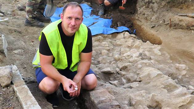 Archeolog Aleš Hoch s jedním z úlomků ze spálených lidských kostí nalezených u třebíčského kostela svatého Martina.