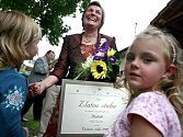 Starostka Hlubokého Marie Svobodová přijímá gratulaci k vítězství v soutěži v roce 2009 od svých vnoučat, Terezky, Aničky a Lucinky.  