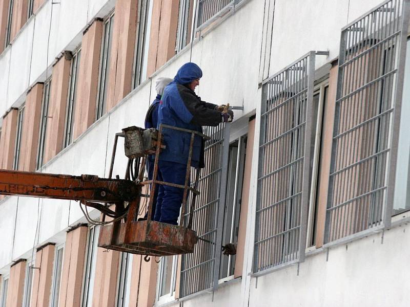 Okna na budově rapotické věznice začínají pokrývat mříže.