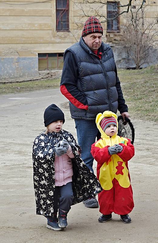 Závěr masopustního průvodu na Jemnickém zámku, kde pan farář za doprovodu masek a diváků pohřbil basu.