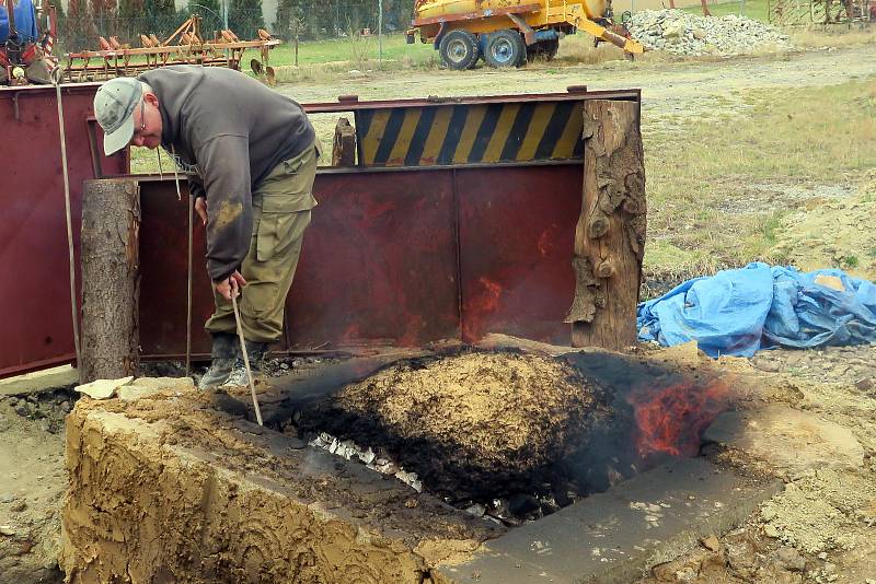 Archeolog Petr Kos přeskupuje vápenec v peci.