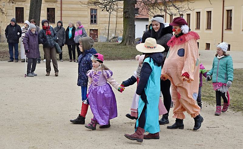 Závěr masopustního průvodu na Jemnickém zámku, kde pan farář za doprovodu masek a diváků pohřbil basu.