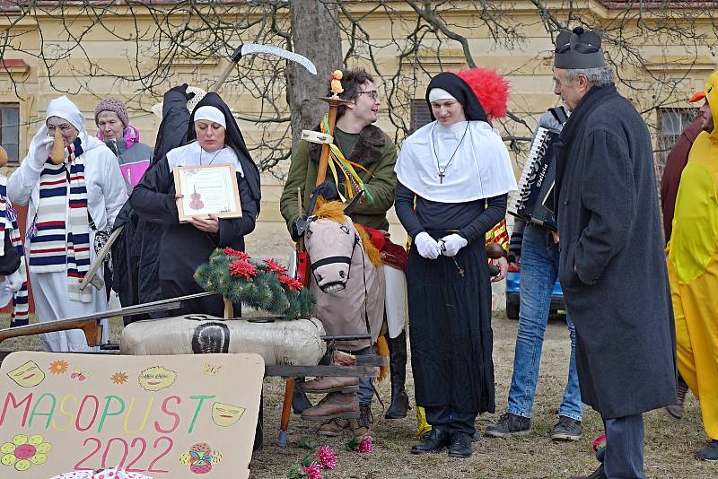 Závěr masopustního průvodu na Jemnickém zámku, kde pan farář za doprovodu masek a diváků pohřbil basu.