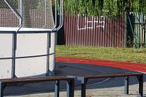 Pomalovaný plot na sportovišti v Okříškách